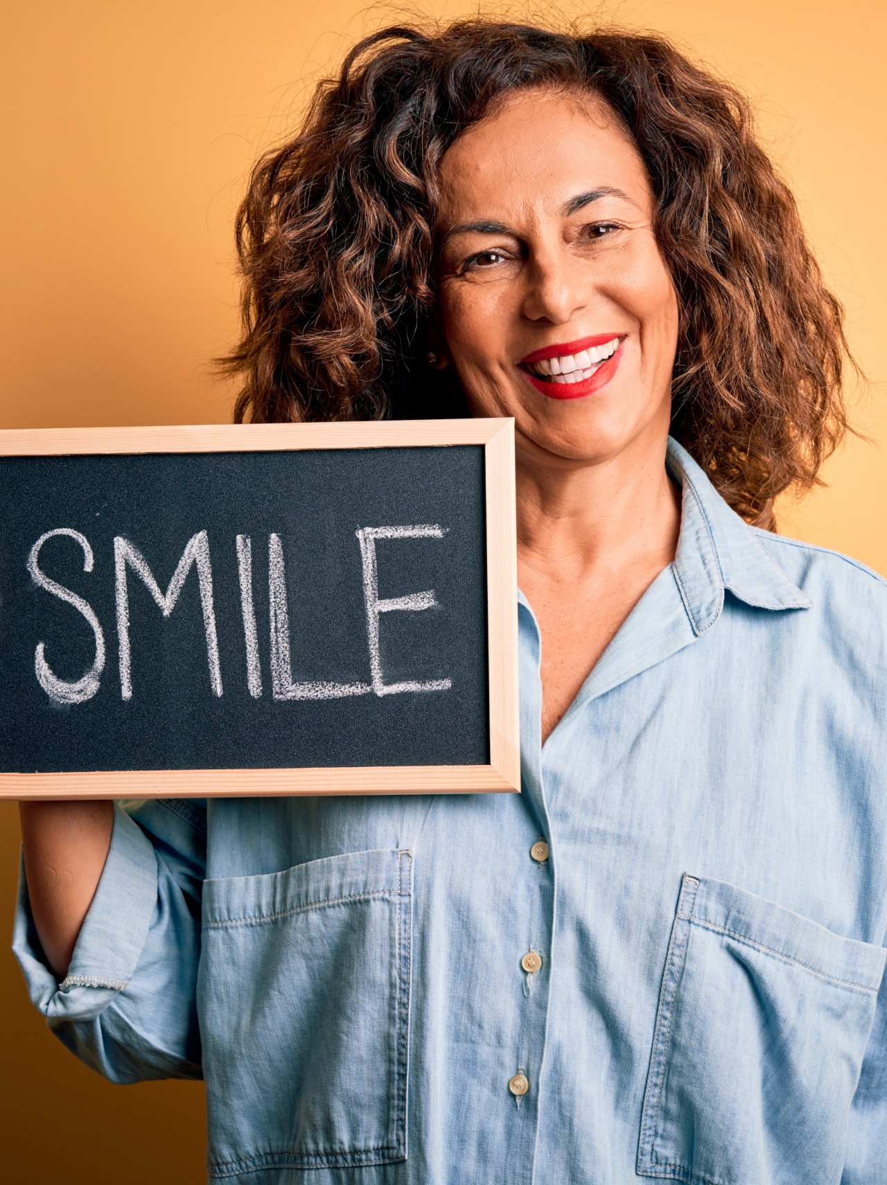 woman holding sign up smiling